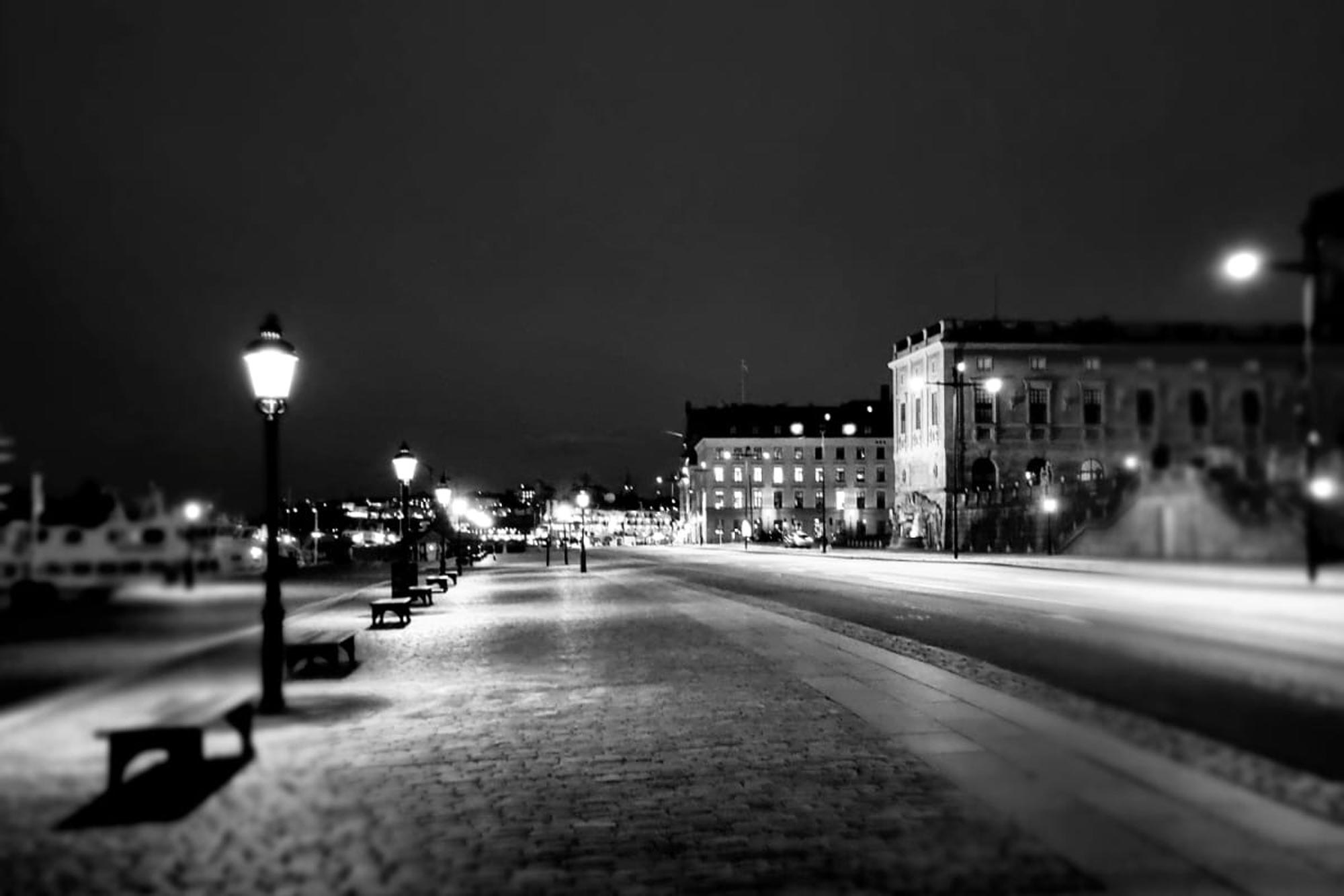 Belyst gångväg med lyktor med eleganta byggnader i stadsmiljö