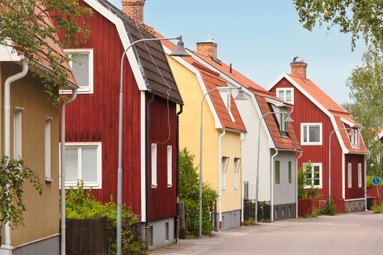 Flera klassiska svenska hus i rad, målade i olika färger, i Falun