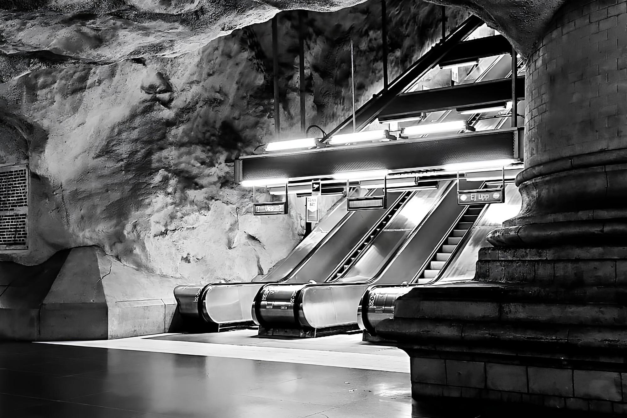 Rulltrappa omgiven av bergväggar på perrongen vid Rådhusets tunnelbana